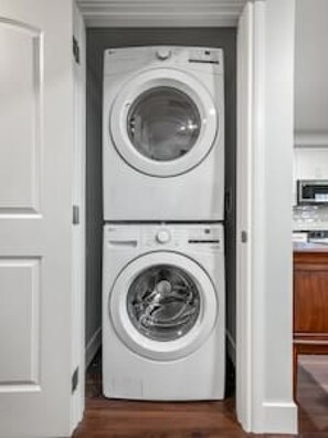 Una sala de bugaderia amb dues rentadoràs apilades.