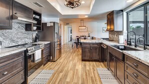 A modern kitchen with dark wood cabinets, stainless steel appliances, and a marble countertop. - Game Room, Pool & Lake Fun at 'indian Land Oasis' (Lake Havasu City)
