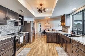 A modern kitchen with dark wood cabinets, stainless steel appliances, and a marble countertop. - Game Room, Pool & Lake Fun at 'indian Land Oasis' (Lake Havasu City)