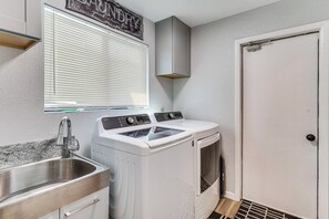 A laundry room with a washing machine, a dryer, a sink, and a door. - Game Room, Pool & Lake Fun at 'indian Land Oasis' (Lake Havasu City)