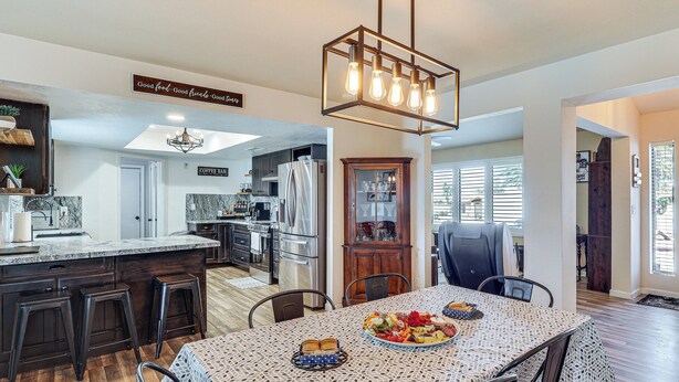 A spacious kitchen with a dining area, wooden bar stools, and a chandelier. - Game Room, Pool & Lake Fun at 'indian Land Oasis' (Lake Havasu City)