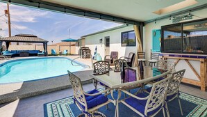 Un'area esterna coperta con piscina, posti a sedere e un bar.