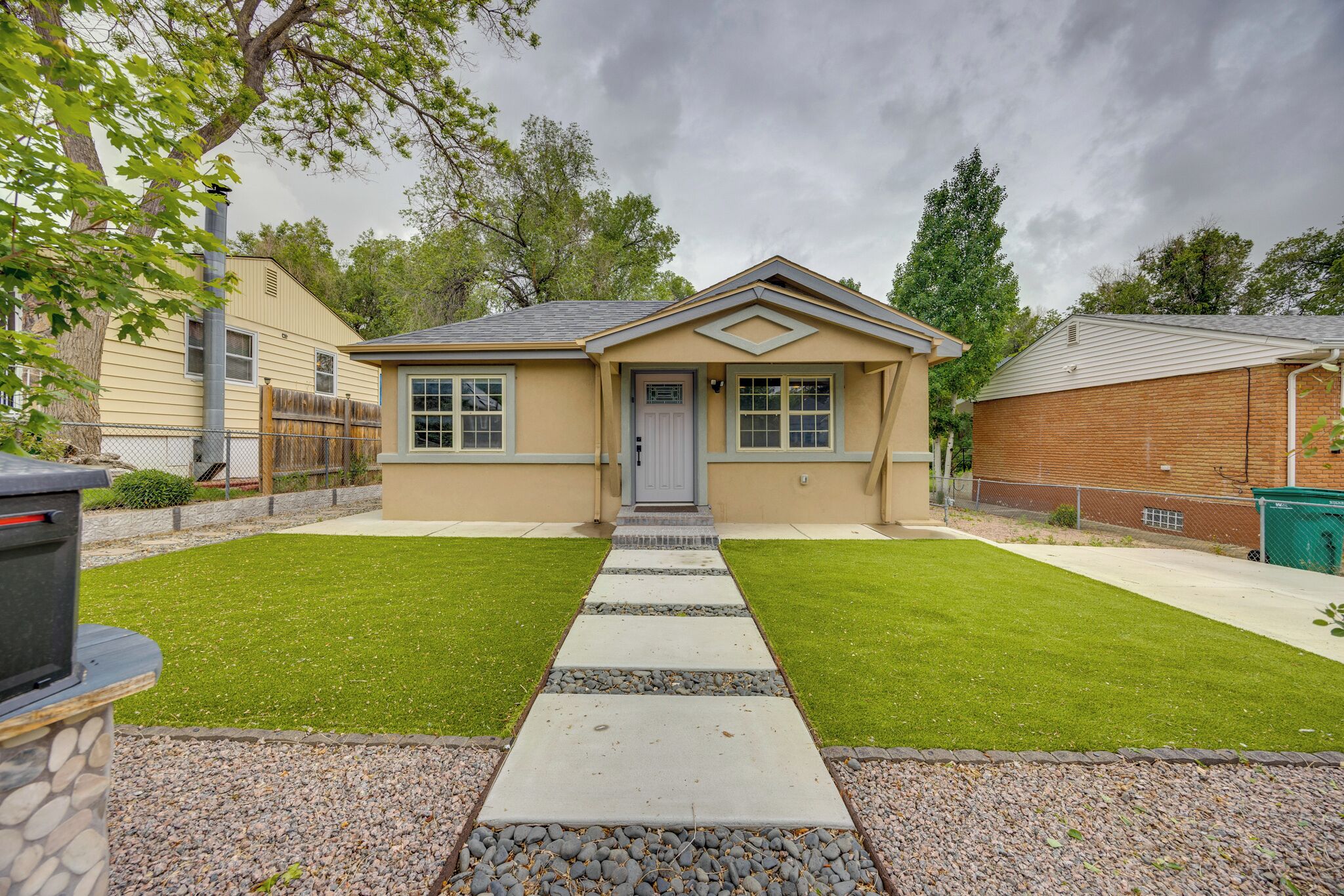 A single-story house with a front door, a small porch, and a well-maintained lawn.