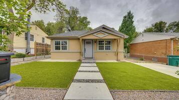 A single-story house with a front door, a small porch, and a well-maintained lawn.