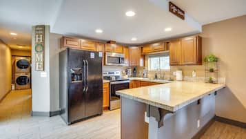 A modern kitchen with wooden cabinets, stainless steel appliances, and a central island.
