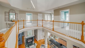 Un intérieur à plusieurs niveaux comprenant un escalier, une cheminée et un coin cuisine.