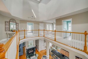 A multi-level interior with a staircase, a fireplace, and a kitchen area. - Walk to Beach! Spacious Surf City Escape (Holly Ridge)