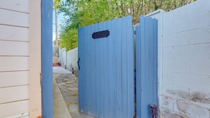 A blue gate, a white wall, and a stone pathway. - Tiny House Experience in Las Vegas w/ Free Parking (Las Vegas)