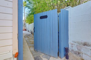 Ein blaues Tor, eine weiße Mauer und ein Steinweg.