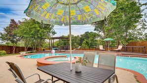 A backyard with a swimming pool, patio furniture, and a pergola. - 3 Mi to Six Flags! Family Getaway w/ Outdoor Oasis (Grand Prairie)