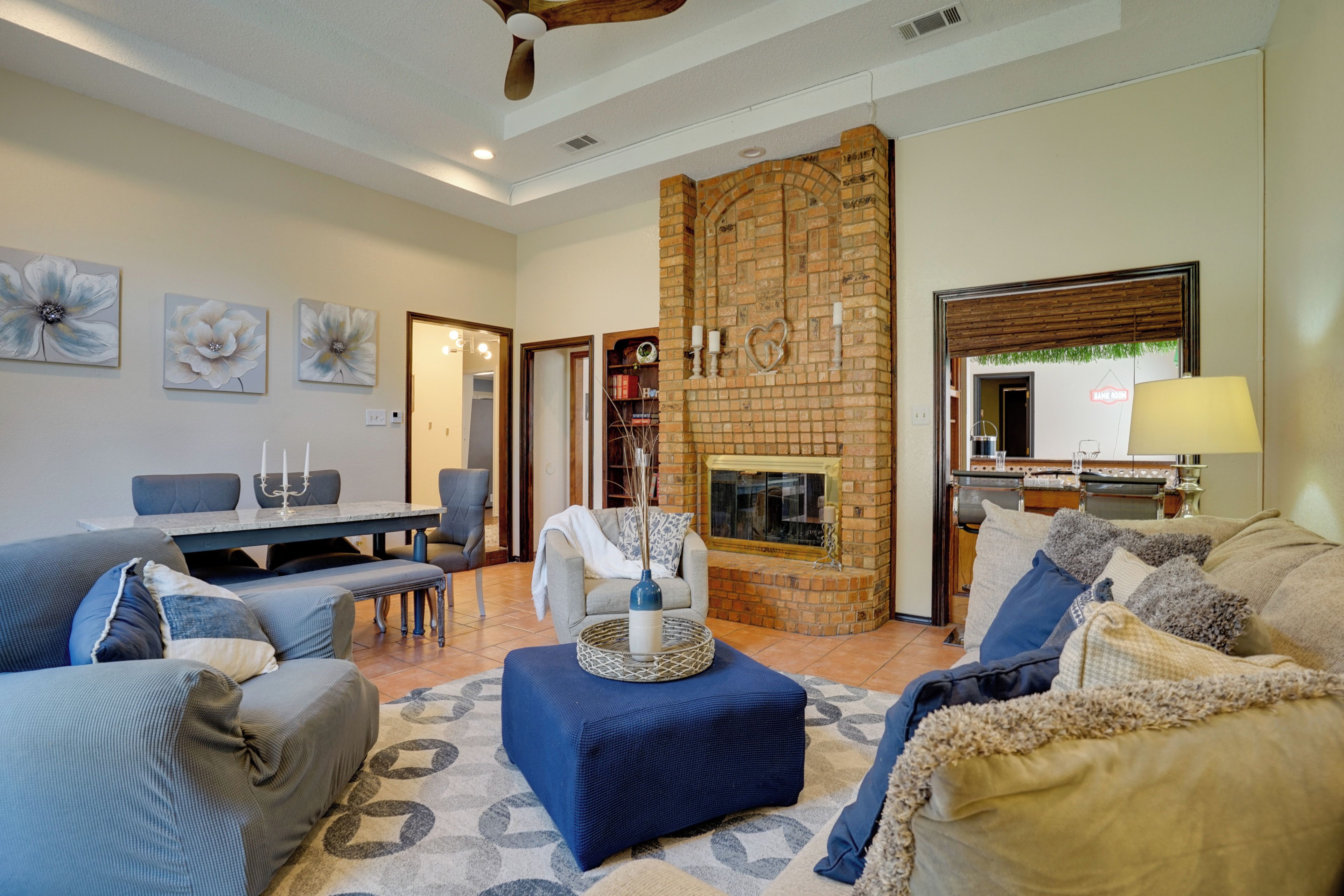 A living room with a fireplace, seating area, and a dining table.