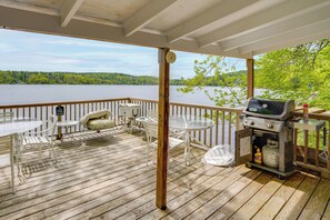 A wooden deck with outdoor furniture, a grill, and a view of a lake. - Waterfront Berkshires Studio w/ Dock on Goose Pond (Lee)