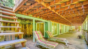 A covered outdoor area with wooden benches and lounge chairs. - Hike, Golf & Explore: Extended Stay in Camp Meeker (Occidental)