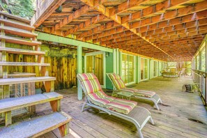 A covered outdoor area with wooden benches and lounge chairs. - Hike, Golf & Explore: Extended Stay in Camp Meeker (Occidental)