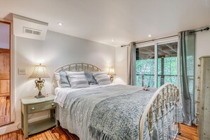 A bedroom with a bed, nightstands, lamps, a window with curtains, and a view of trees. - Hike, Golf & Explore: Extended Stay in Camp Meeker (Occidental)