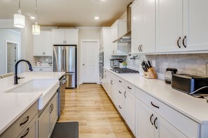 A modern kitchen with white cabinets, stainless steel appliances, and pendant lighting. - 5 Mi to Bethany Beach! Group Escape w/ Pool Access (Ocean View)