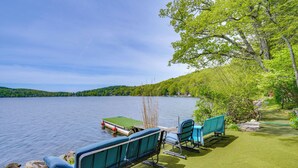 A lakeside setting with a dock, boats, and outdoor seating. - Lakeside Berkshires Cabin w/ Private Dock & Views (Lee)