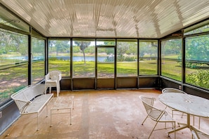A covered patio with a view of a lake, metal chairs, and a table. - Patio w/ Views! Pet-friendly Keystone Heights Home (Keystone Heights)