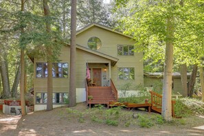 A two-story house with a front porch, a circular window, and a flag.