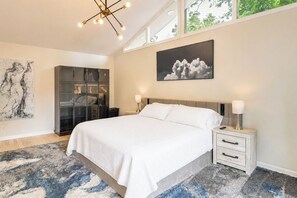 A bedroom with a bed, bedside tables, a wardrobe, a large abstract painting, and a cloud photograph on the wall. - Game Room! Upscale Family Retreat in Murfreesboro (Murfreesboro)