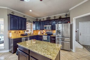 Una cocina con armarios de madera oscura, electrodomésticos de acero inoxidable y encimera de granito.