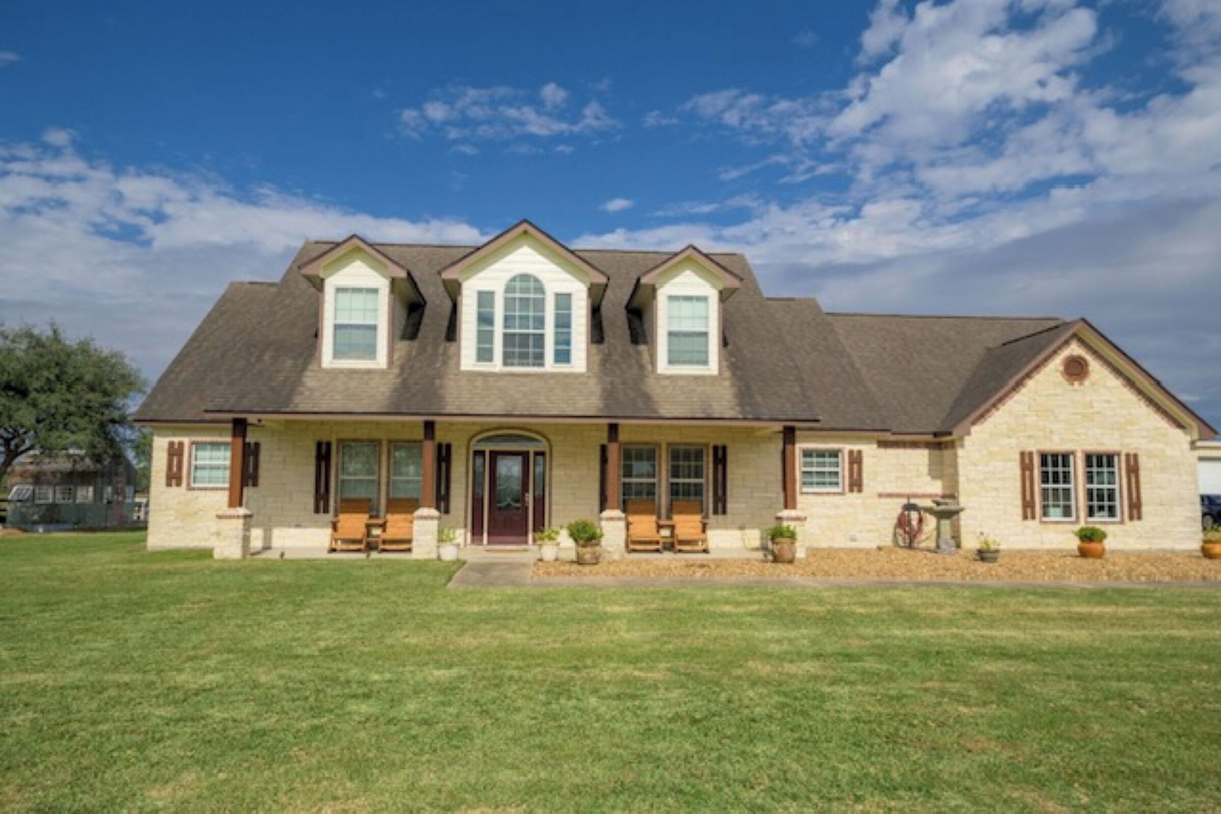 A two-story house with a front porch, a garage, and a well-maintained lawn.