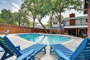 A backyard with a swimming pool, blue lounge chairs, and a wooden fence. - Hot Tub & Game Room! Home 15 Mi to At&t Stadium (North Richland Hills)