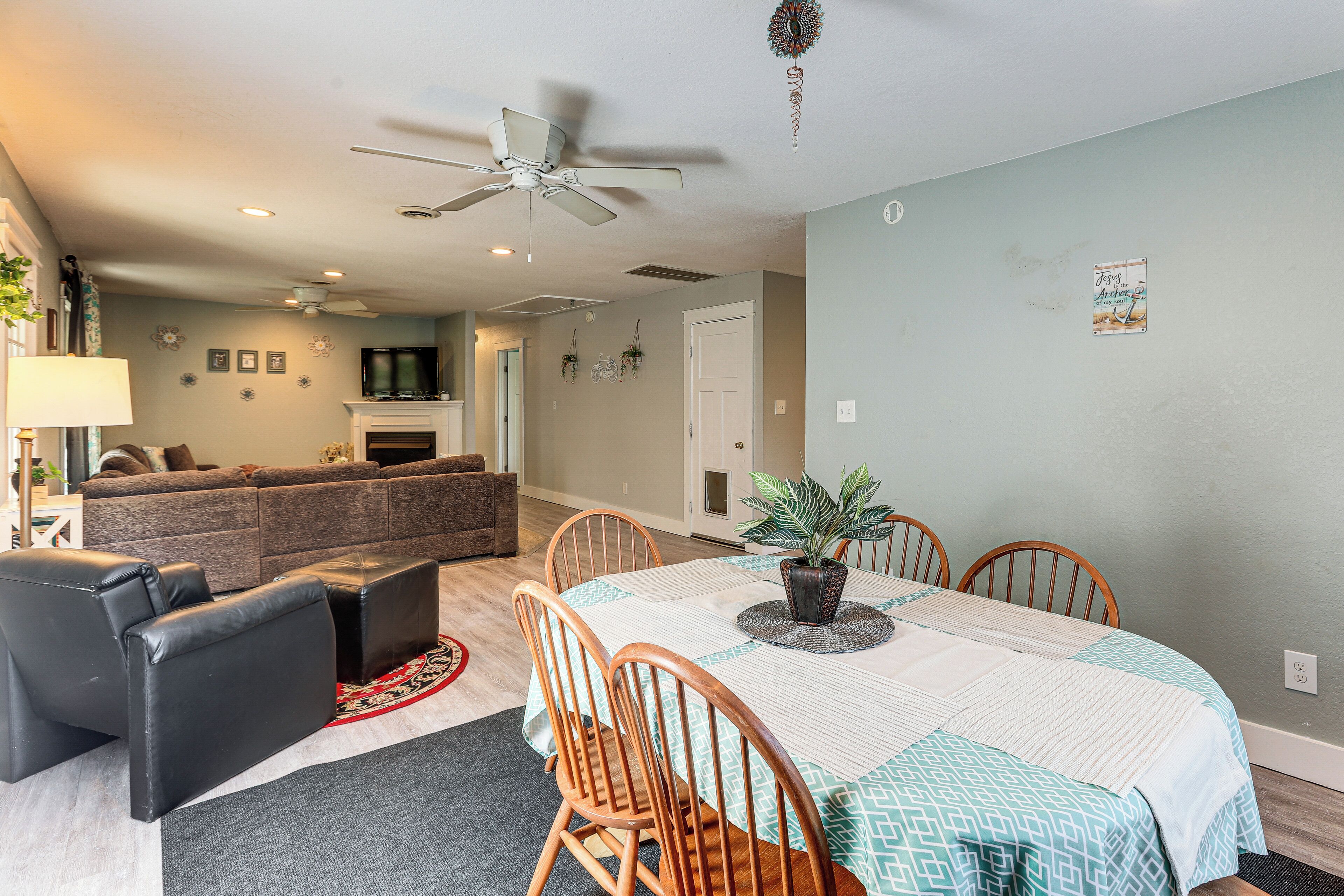 A dining area with a table, chairs, and a ceiling fan.