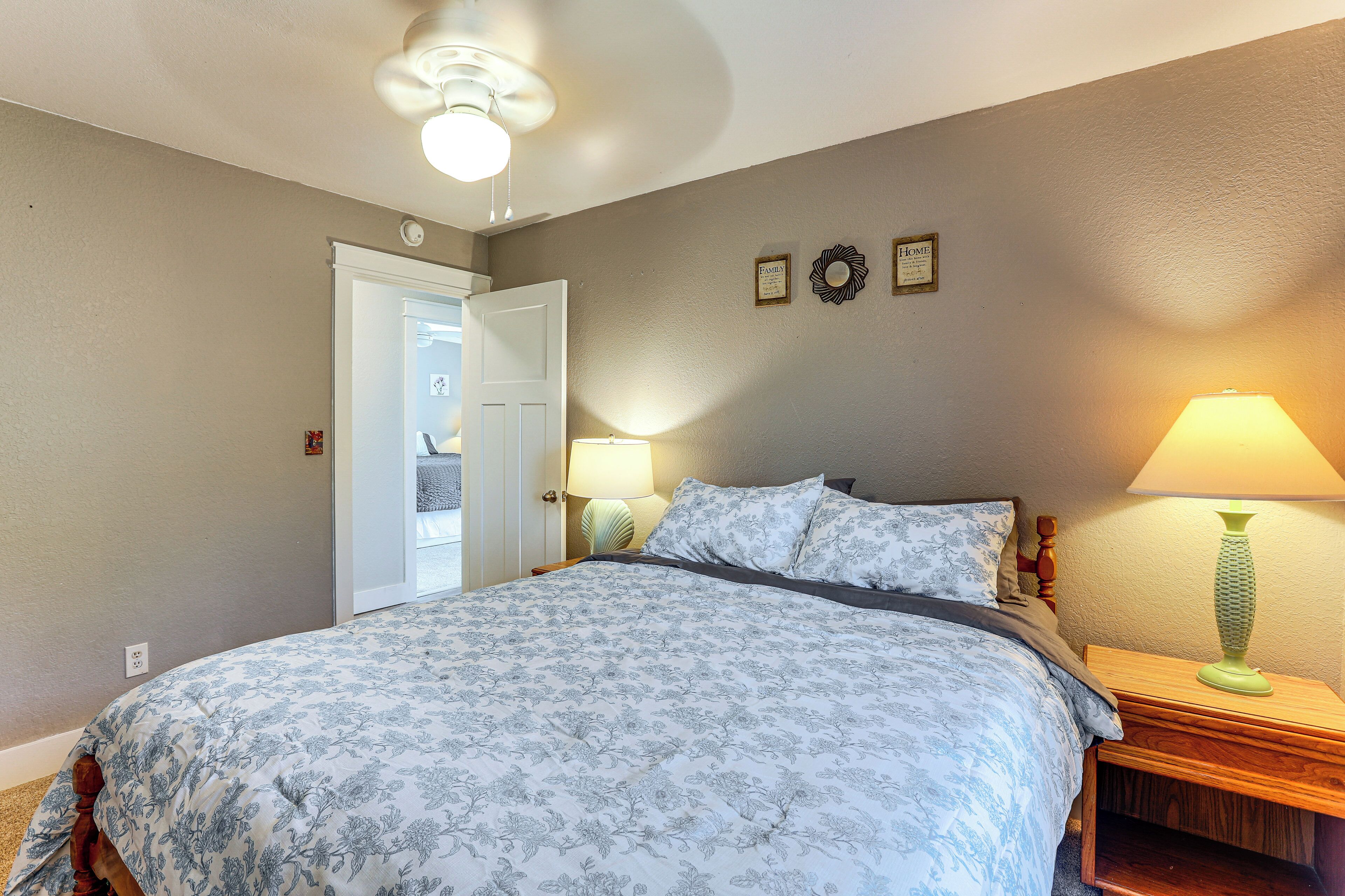 Une chambre à coucher avec un lit, des lampes de chevet, une porte et des éléments décoratifs sur les murs.
