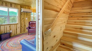 A wooden interior with a staircase, a leather chair, and a colorful rug. - Pet-friendly Home w/ Stunning Views in Sparta! (Sparta)