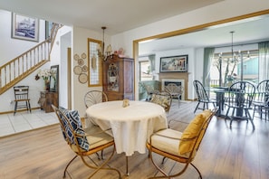 A dining area with a round table, chairs, and a fireplace.