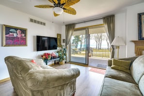 A living room with two sofas, a television, and a ceiling fan.