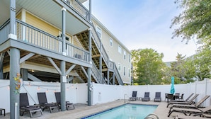 A pool area with lounge chairs, a staircase, and a white fence. - Shared Pool & Hot Tub! Seaside Murrells Inlet Home (Murrells Inlet)