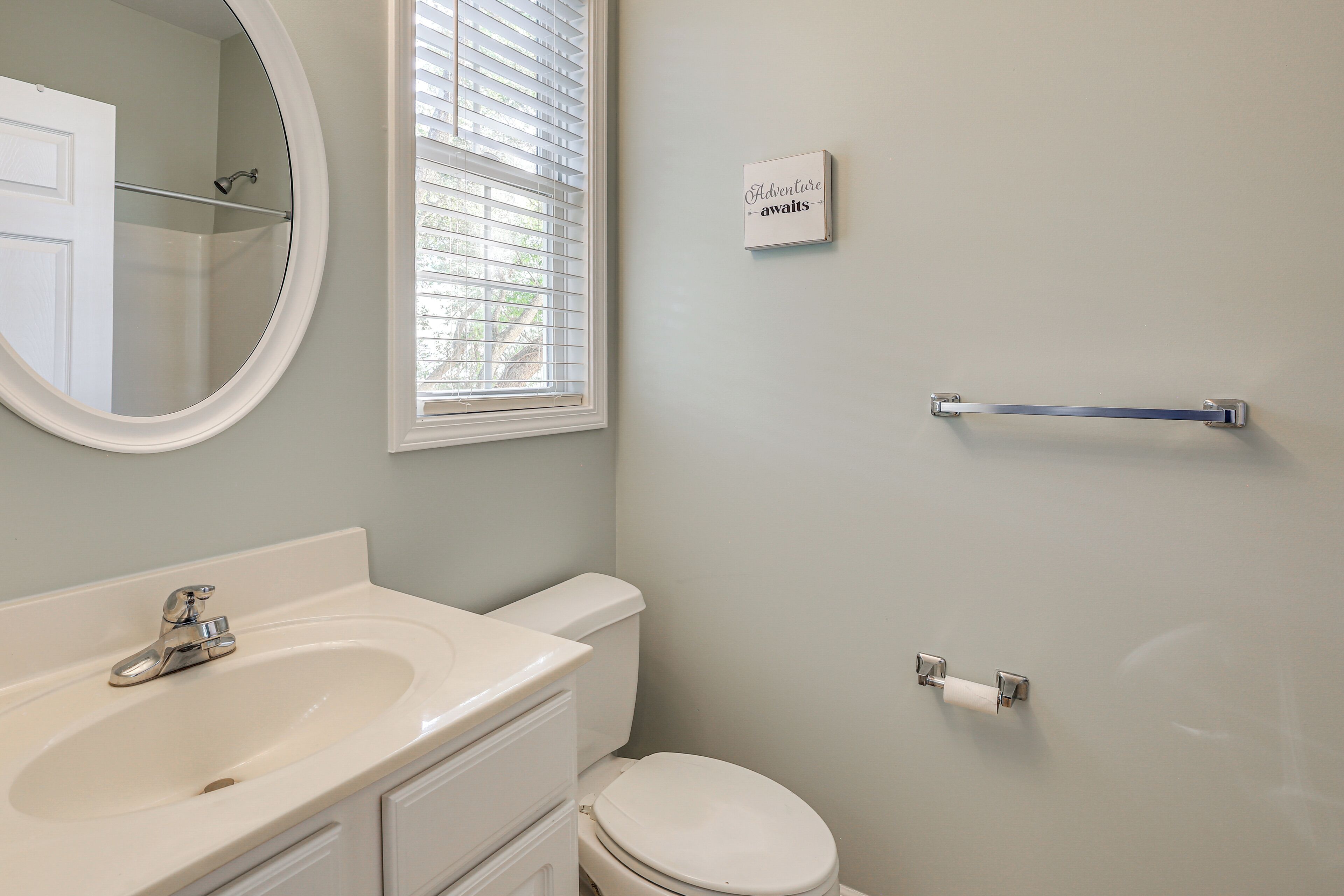A bathroom with a sink, toilet, and a towel rack.