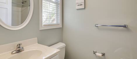 A bathroom with a sink, toilet, and a towel rack.