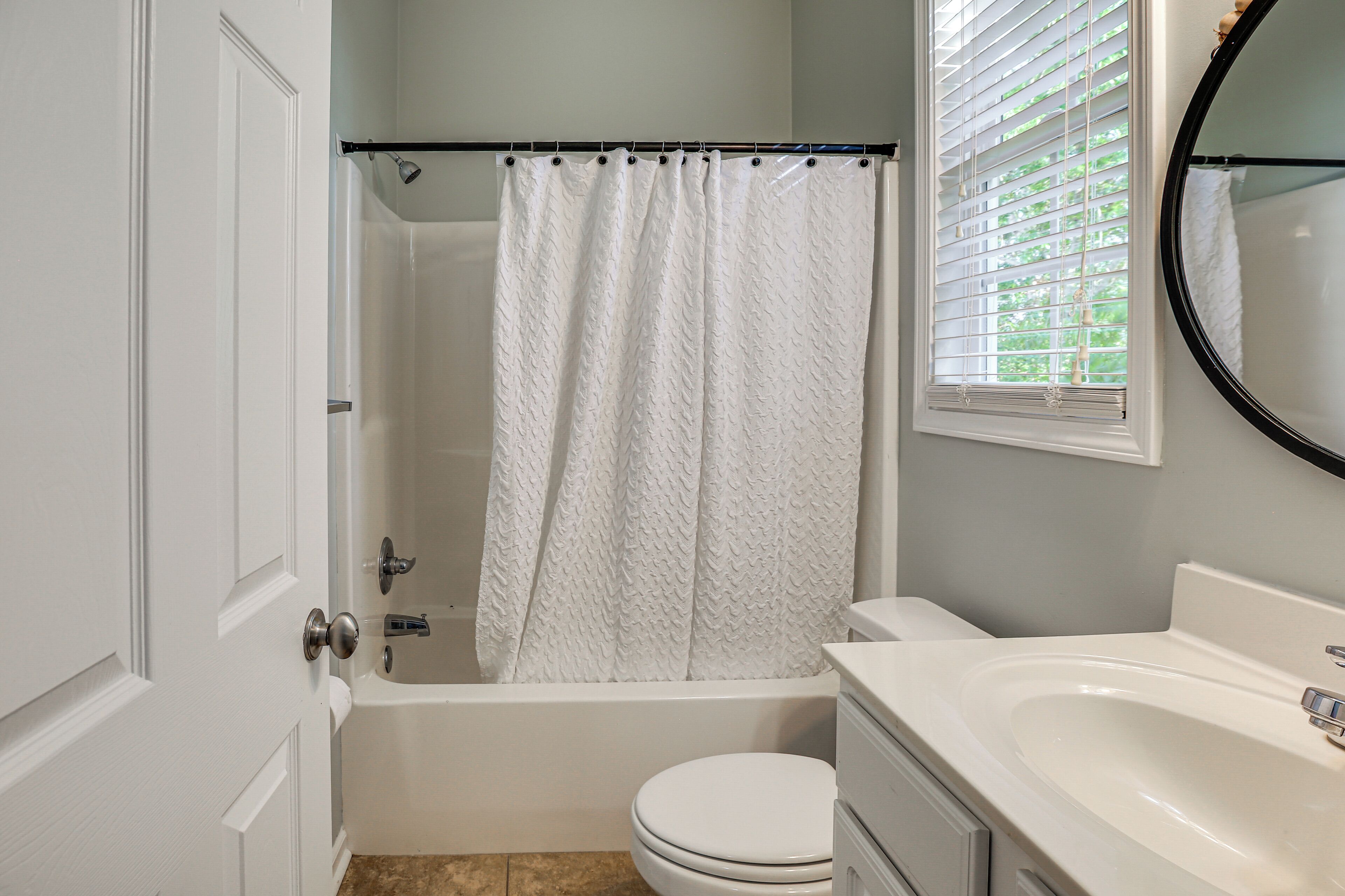A bathroom with a bathtub, toilet, and sink.