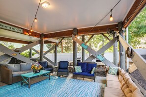A covered outdoor seating area with wicker furniture, a blue table, and string lights. - Walk to Beach! Murrells Inlet Oasis w/ Shared Pool (Murrells Inlet)