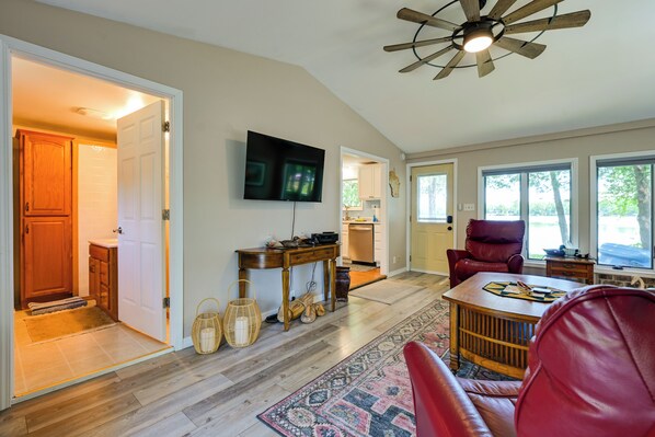 A spacious living room with a ceiling fan, a television, and a red leather chair. - Waterfront Days, Fireside Nights! Lake Helen Haven (Rosholt)