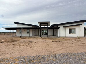 A modern two-story house with a covered patio, a garage, and a fenced yard. - Enjoyable family friendly 4-bedroom Solar home close to Atessa Podium Club, (Casa Grande)