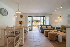 A well-lit living area with a dining table, chairs, a sofa, and a coffee table. - Cozy Beach House (El Médano)