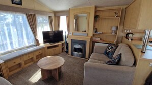 A cozy living room with a television, sofa, and a fireplace. - Fieldview Lodge Dog Friendly nr Anderby Creek (Alford)