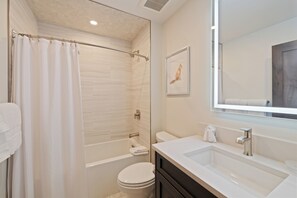 A modern bathroom with a glass shower enclosure, a bathtub, a toilet, and a vanity with a mirror. - Beaver Creek Slope-Side Luxury | UB306 (Beaver Creek)