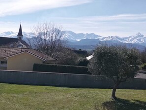 Un barrio residencial con una iglesia, un pequeño edificio y montañas nevadas al fondo.
