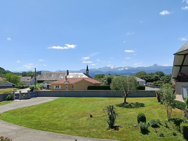 Un barrio residencial con casas, una iglesia y una cordillera al fondo.