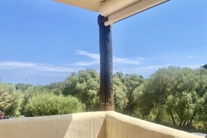 Ein Balkon mit Blick auf Bäume und einen klaren Himmel.