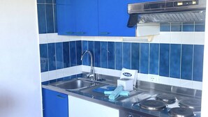 A kitchen with blue cabinets, a stainless steel sink, and a stove. - Porto Rotondo Bilo4 A208 in residence with swimming pool (Porto Rotondo)