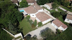 Vue aérienne d’un quartier résidentiel avec des maisons, une piscine et une allée pavée.