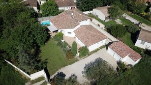 An aerial view of a residential area with houses, a swimming pool, and a paved driveway. - Large Provencal house (Pujaut)