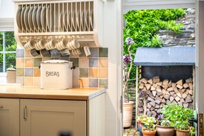 Une cuisine équipée d’un récipient à pain, d’un égouttoir et d’un pare-feu en carreaux.