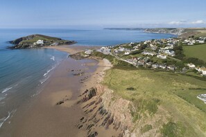 Vue aérienne d’une ville côtière avec une plage, des maisons et des falaises.